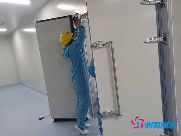 图为浩爽工人在洁净冷库为库门打胶
